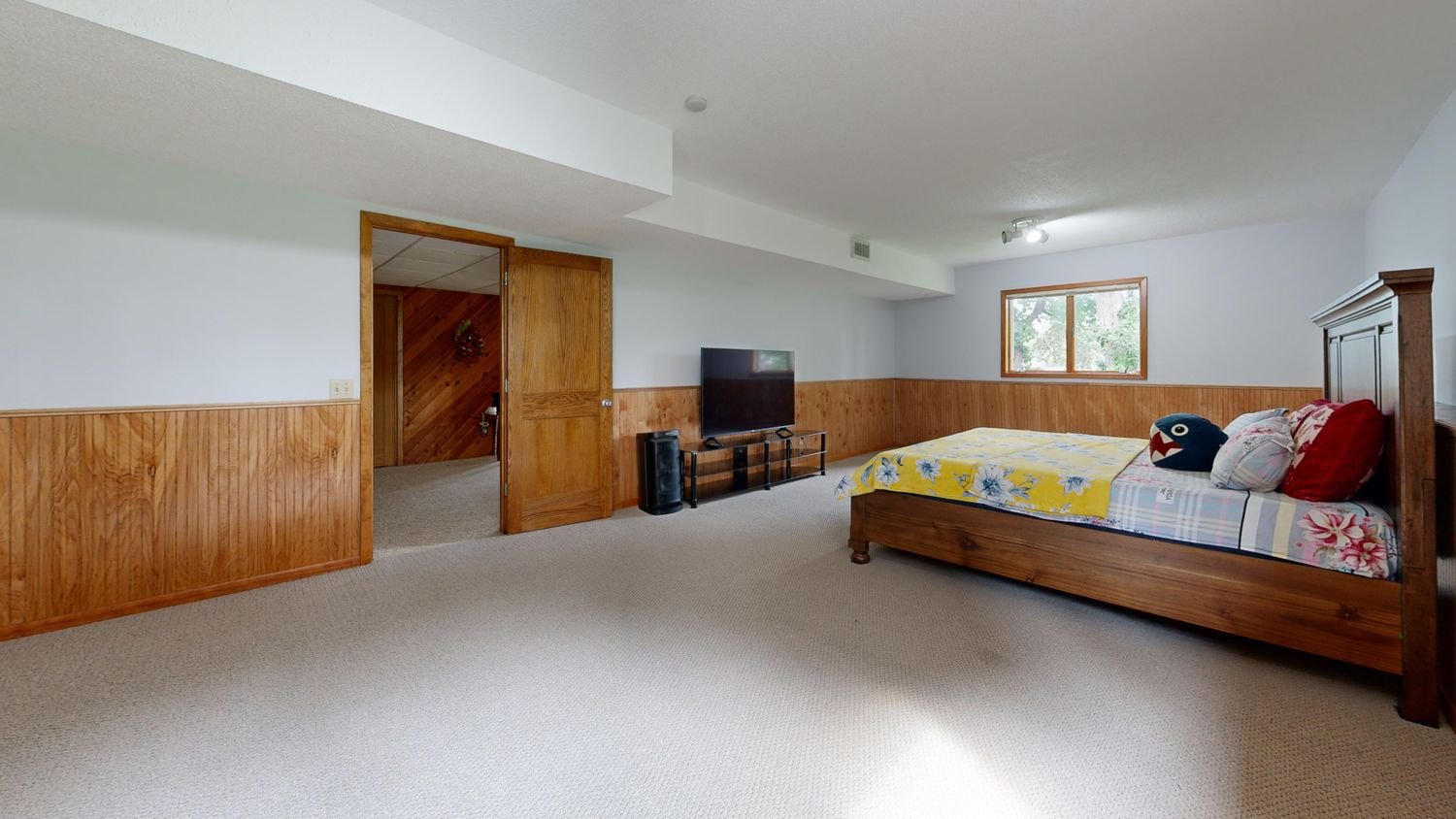 Finished basement bedroom with wood accents and soft lighting
