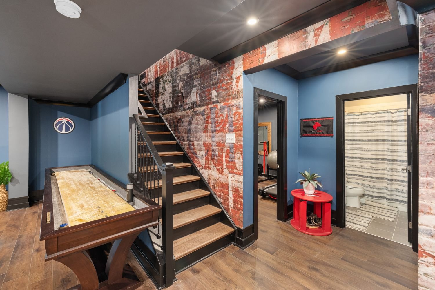Finished basement with a games area beside the staircase