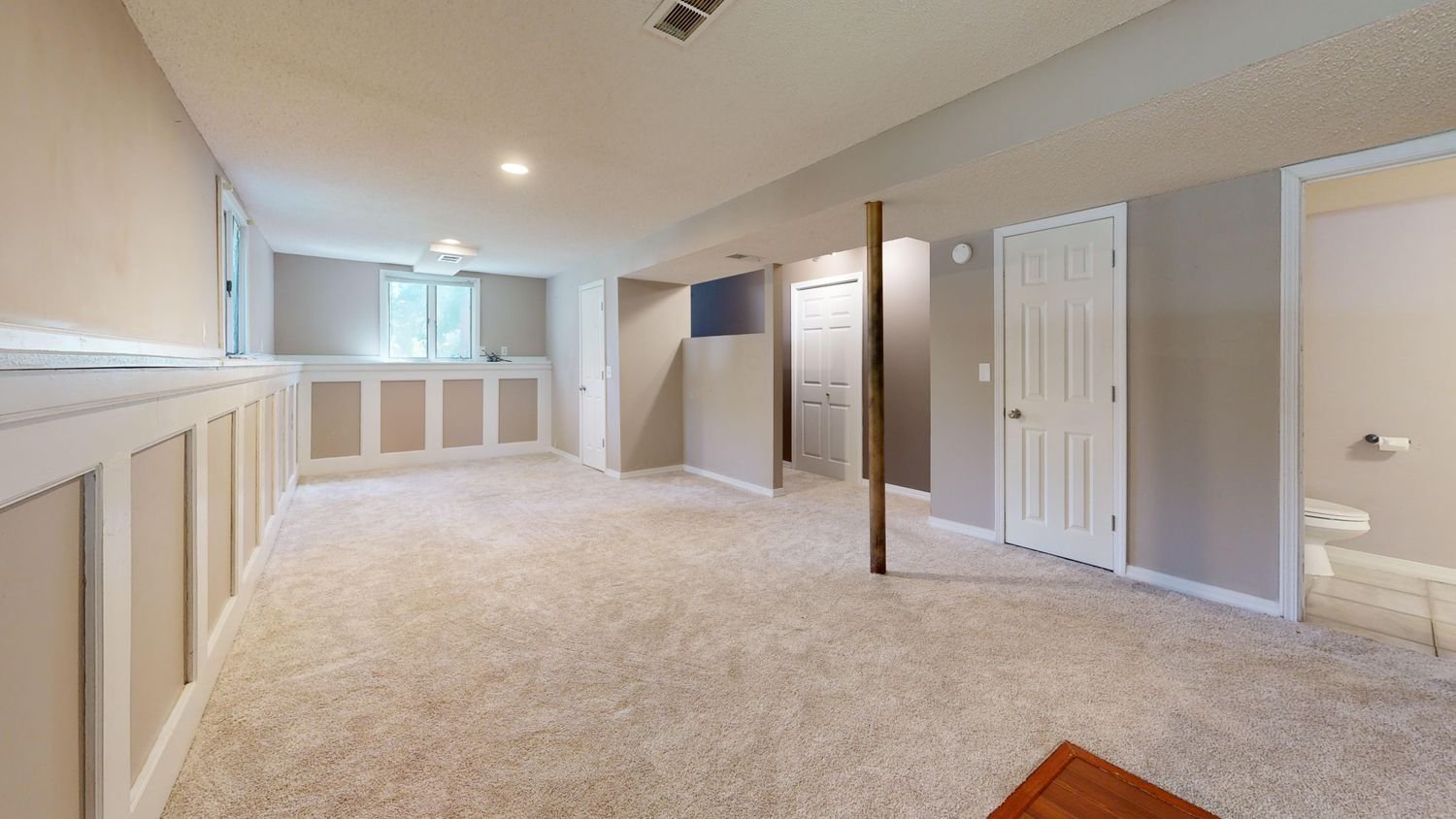 Bright finished basement with carpet flooring and recessed lighting